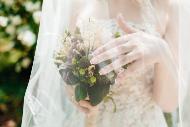 Düğün resmi ve kırmızı çiçekli bir gelin buketi.