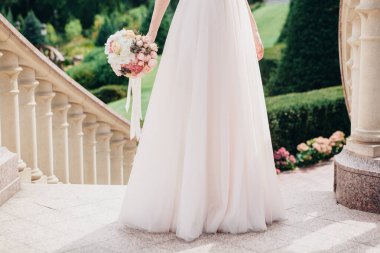 Düğün resmi ve kırmızı çiçekli bir gelin buketi.