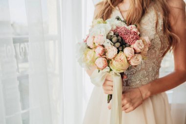 Düğün resmi ve kırmızı çiçekli bir gelin buketi.