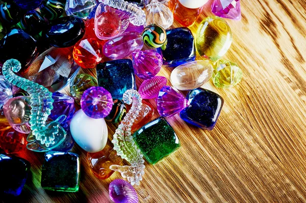 Lote de coloridas perlas de vidrio y colores brillantes en madera — Foto de Stock