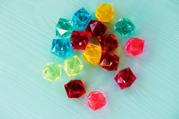 Glass beads diamonds on turquoise wooden background — Stock Photo, Image
