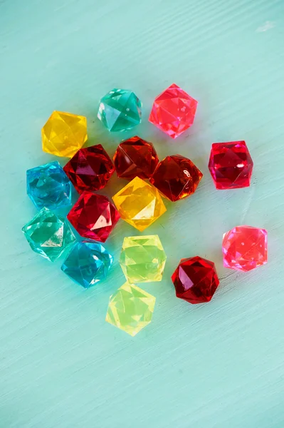 Glass beads diamonds on turquoise wooden background — Stock Photo, Image