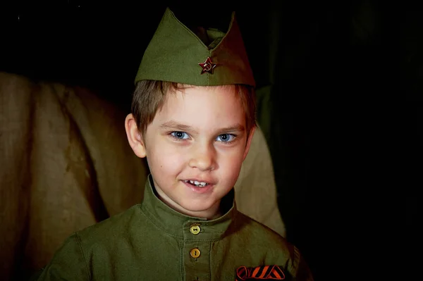 Anos de idade menino na forma militar russa, bonito com olhos azuis . — Fotografia de Stock