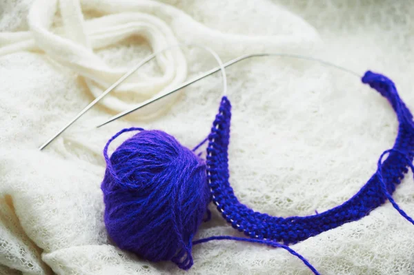 Sur un fond blanc repose une boule de laine, tricot — Photo