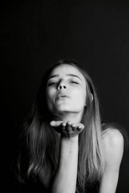 Uzun saçlı güzel kız bir öpücük gönderir.