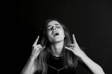 Genç güzel kız. Rock n roll parmak işaret.