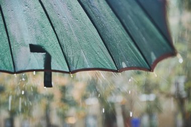 Şemsiye düşen yağmur damlaları. Bulutlu, nem.