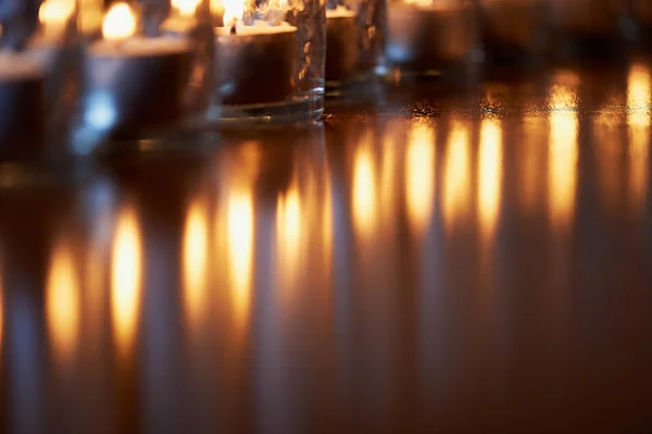 Палаючі свічки в прозорих окулярах, блискуча підлога, відображення. Настрій, релаксація, молитва і затишок — стокове фото