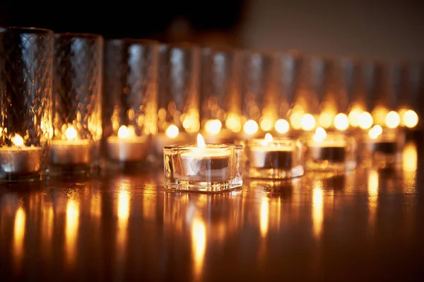 Αναμμένα κεριά σε διαφανή ποτήρια, γυαλιστερό πάτωμα, την αντανάκλαση. Διάθεση, την χαλάρωση, την προσευχή και την άνεση — Φωτογραφία Αρχείου