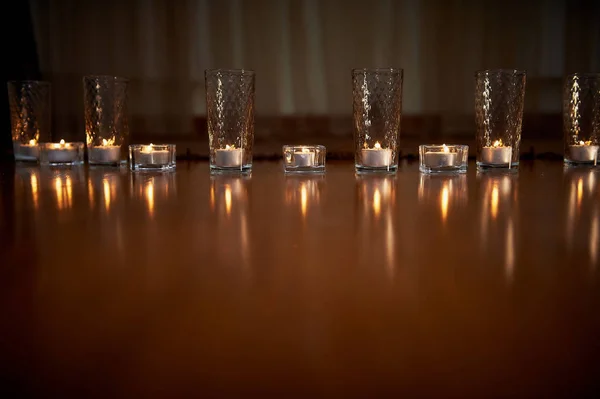 Brennende Kerzen in durchsichtigen Gläsern, glänzender Boden, das Spiegelbild. Stimmung, Entspannung, Gebet und Trost — Stockfoto