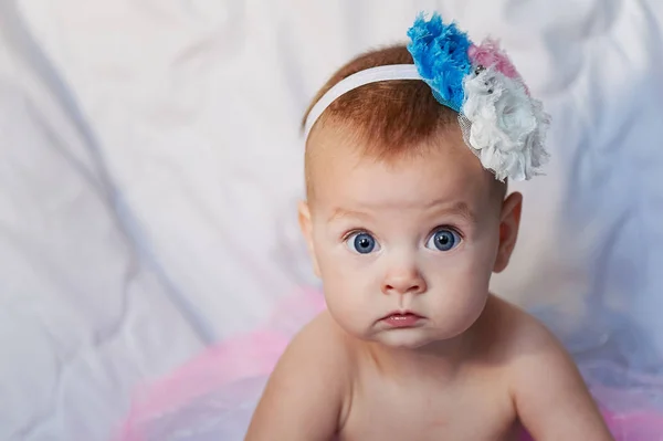 Bebé recién nacido con una corona de ganchillo blanco, tutú bailarina, y zapatillas de ballet. Ella está durmiendo en rosa rosa tela de la cinta . —  Fotos de Stock