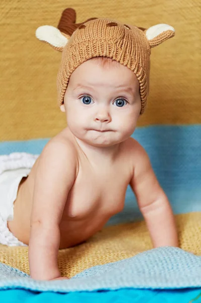Kleine pasgeboren baby met grote ogen hoed-breien op een effen achtergrond. — Stockfoto