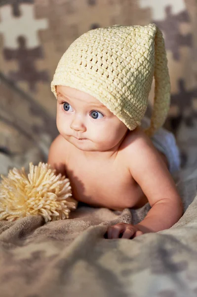 Novorozené miminko s velkýma očima hat pletení na pozadí. — Stock fotografie