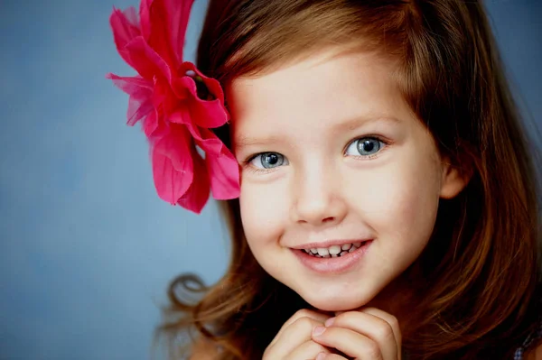 Όμορφο μικρό κορίτσι με το κόκκινο κοκαλάκι σε σχήμα λουλούδι στα μαλλιά — Φωτογραφία Αρχείου