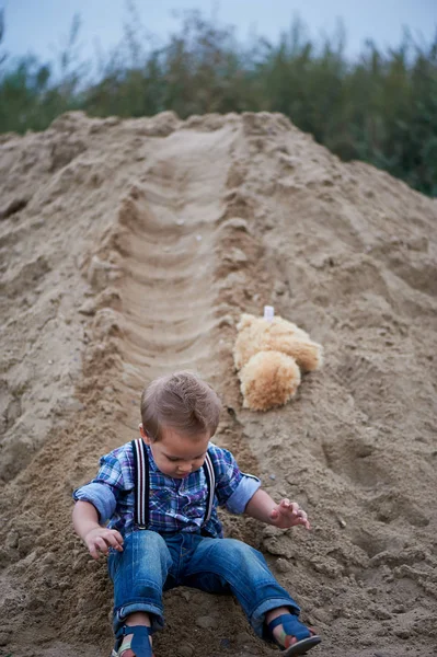 Aranyos kisfiú lovaglás egy hullámvasút, a homok alján. Gyermekkori emlékek és gondtalan — Stock Fotó