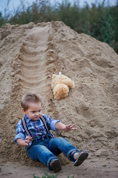 Kleiner süßer Junge, der eine Achterbahn aus Sand auf dem Boden reitet. Kindheitserinnerungen und unbeschwerte — Stockfoto