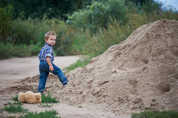 Roztomilý malý chlapec stojící poblíž velkou hromadu. Vzpomínky na dětství a bezstarostné — Stock fotografie