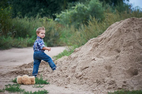 Roztomilý malý chlapec stojící poblíž velkou hromadu. Vzpomínky na dětství a bezstarostné — Stock fotografie