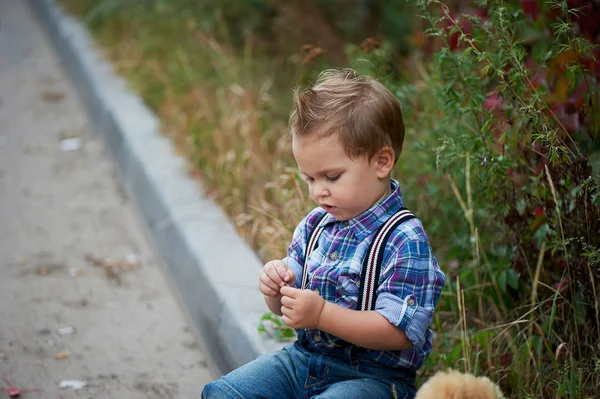 Aranyos kisfiú ül a járda. Emlékek a gyermekkor és a gondtalan — Stock Fotó