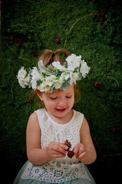 Krásná holčička v věnec na hlavu v zelené a bílé. Party šaty, princezna. — Stock fotografie