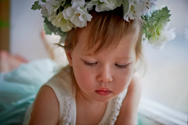 Krásná holčička v věnec na hlavu v zelené a bílé. Party šaty, princezna. — Stock fotografie