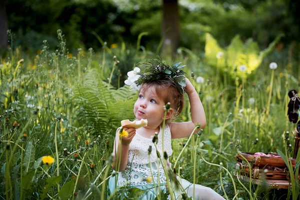 Krásná holčička v věnec na hlavu v zelené a bílé. Šaty, princezna. S radostí, ale přírodě — Stock fotografie