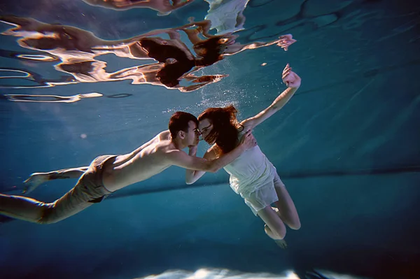 A legtisztább víz a medencében víz alatti. Szerető pár átölelve. Az érzés, a szeretet és a közelség — Stock Fotó