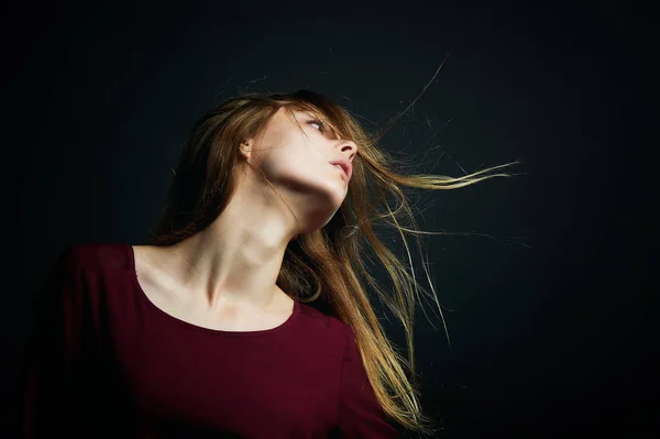 La mano en su cabello. Hermosa joven bailando. Cabello volando. Tiro en Studio sobre fondo oscuro —  Fotos de Stock