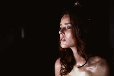 Stüdyo portre uzun saçlı güzel bir kız. Yüzünde parıltı. Güzel gözler. Koyu arka plan. Gizemli, mistik, zarif