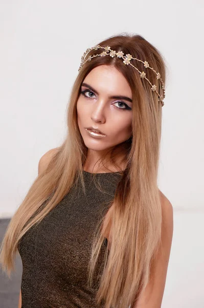 Krásná dívka model v Studio natáčení krásy. Zlaté make-up, dlouhé vlasy, zlatý vrch. Teplý — Stock fotografie