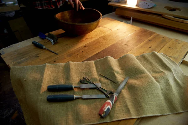 Mãos masculinas segurando tigela grande de madeira. Tratamento de superfície na oficina . — Fotografia de Stock