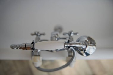 Banyo aksesuarları. Mikser ve duş. Açık diyafram, odak üstünde belgili tanımlık tafsilât. Renk: gümüş, krom