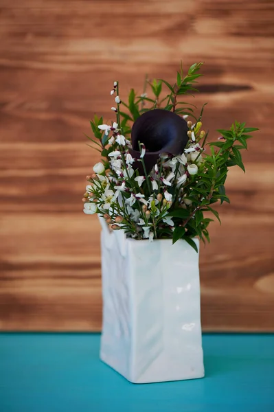 Flores brancas da primavera em vaso de cerâmica branca na forma de um pacote. Minimalismo — Fotografia de Stock