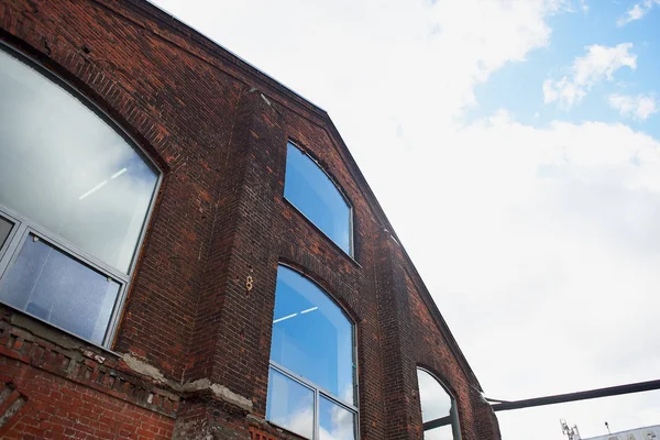 Старое кирпичное здание из красного кирпича напротив неба. Большие окна. Старая фабрика — стоковое фото