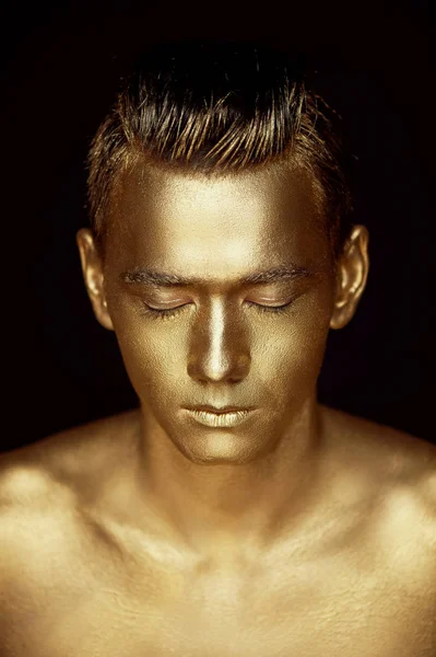 Красивый мужчина спортивного телосложения, полностью покрытый золотой краской. Фотографии студии — стоковое фото