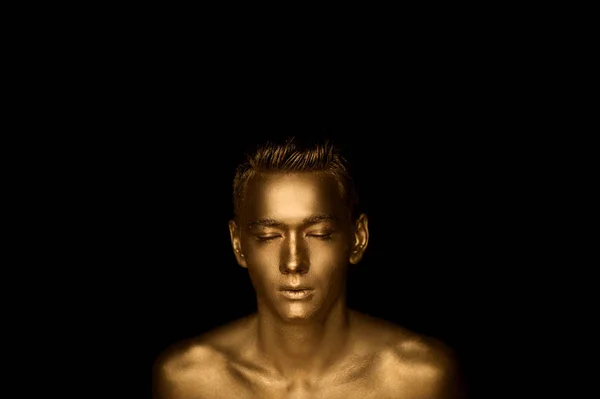 A handsome man of athletic build, completely covered in gold paint. Studio photos — Stock Photo, Image