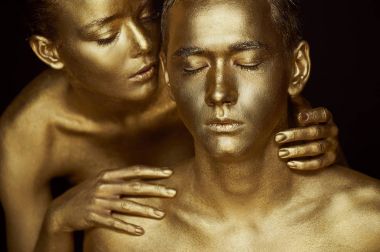 Bir kız ve bir adam altın boya kaplı. Gözlerim kapalı. Kız eğildi