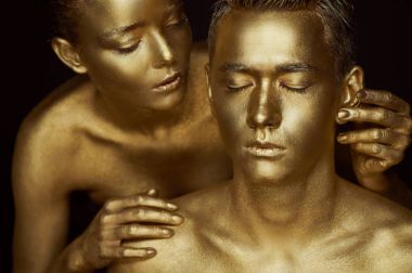 Bir kız ve bir adam altın boya kaplı. Gözlerim kapalı. Kız eğildi