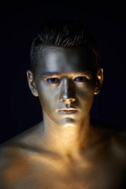 Atletik yapılı, yakışıklı bir adam tamamen altın boya kaplı. Studio fotoğraf. Sabit ile lite