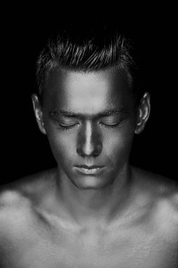 Atletik yapılı, yakışıklı bir adam tamamen altın boya kaplı. Studio fotoğraf. Siyah ve beyaz