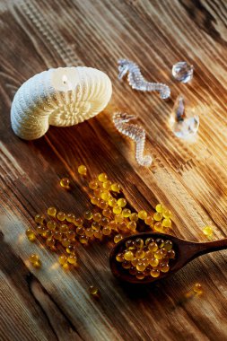 Deniz kabukları, balık yağı ve ahşap yüzey üzerinde bir deniz atı şeklinde mum