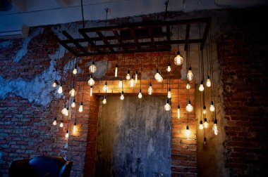 Edison ampul uzun bir tel üzerinde asılı. Sıcak sıcak sarı ışık. Retro