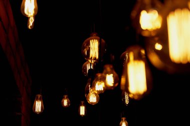 Edison ampul uzun bir tel üzerinde asılı. Sıcak sıcak sarı ışık. Retro