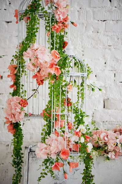Wedding decor. Cage, entwined with roses and ivy, white and elongated