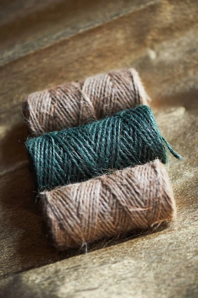 A ball of jute thick threads of brown and green.3 skeins