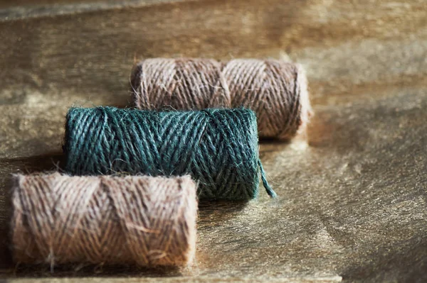 A ball of jute thick threads of brown and green.3 skeins