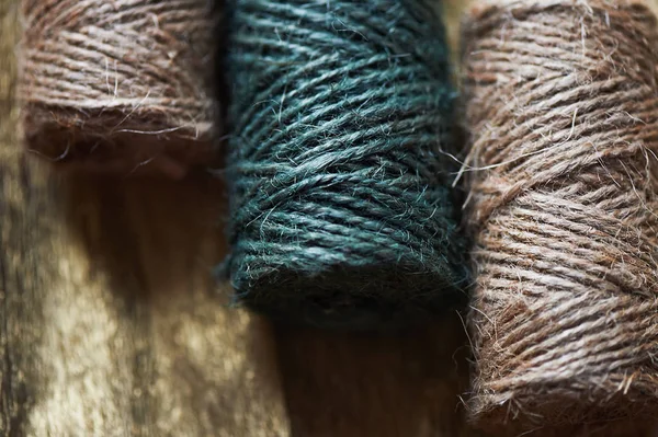 A ball of jute thick threads of brown and green.3 skeins