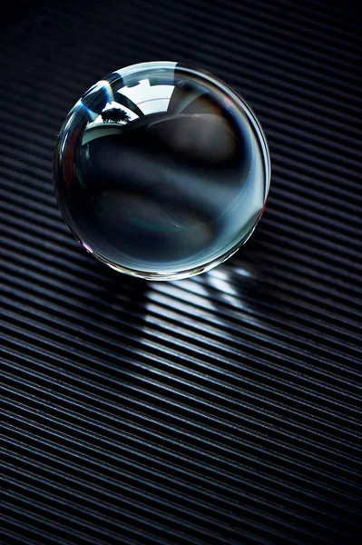 Glazen globe of druppel water op een donkere grafiet gegolfd papier. Reinigen en glanzen — Stockfoto