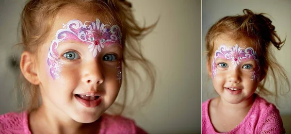 Bastante emocionante chica de ojos azules de 2 años con una pintura de la cara —  Fotos de Stock