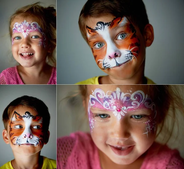 Niño de 6 años con ojos azules pintando la cara de un gato o un tigre. Bastante emocionante chica de ojos azules de 2 años con una pintura de la cara —  Fotos de Stock